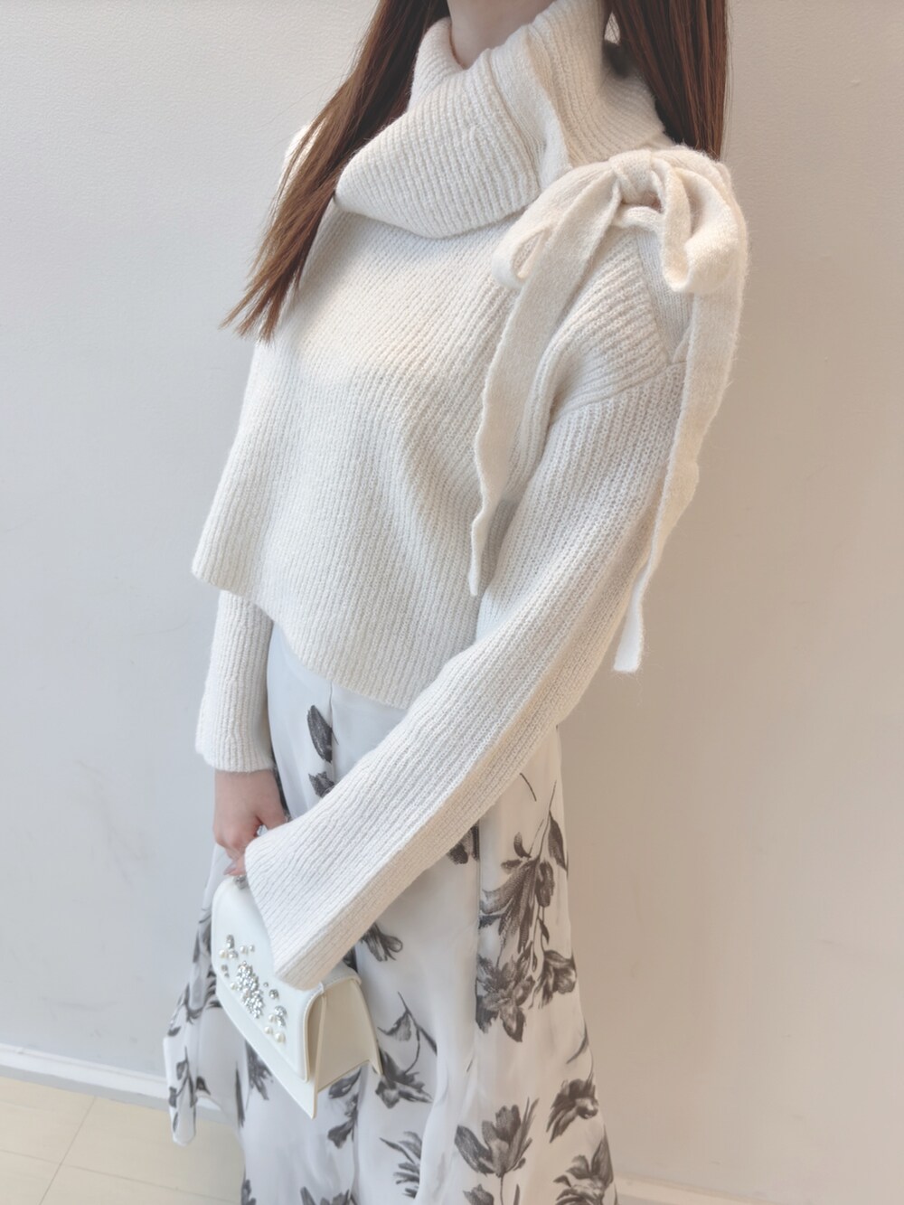ホワイト系のニット/セーター、ホワイト系のスカート、ホワイト系のショルダーバッグを着用したレディースの秋コーディネートの7枚目の写真