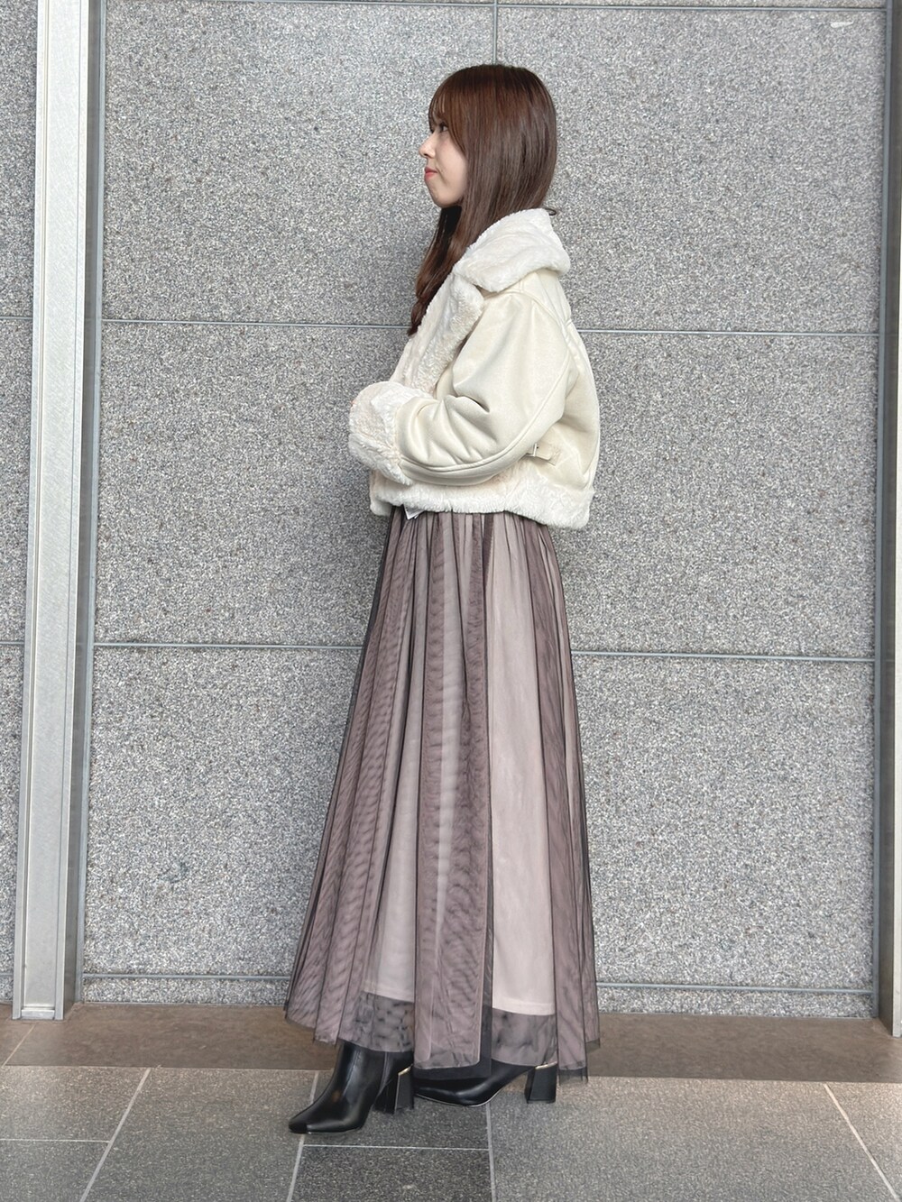 ホワイト系のムートンコート、ブラック系のワンピース、ブラック系のブーツを着用したレディースの秋コーディネートの4枚目の写真