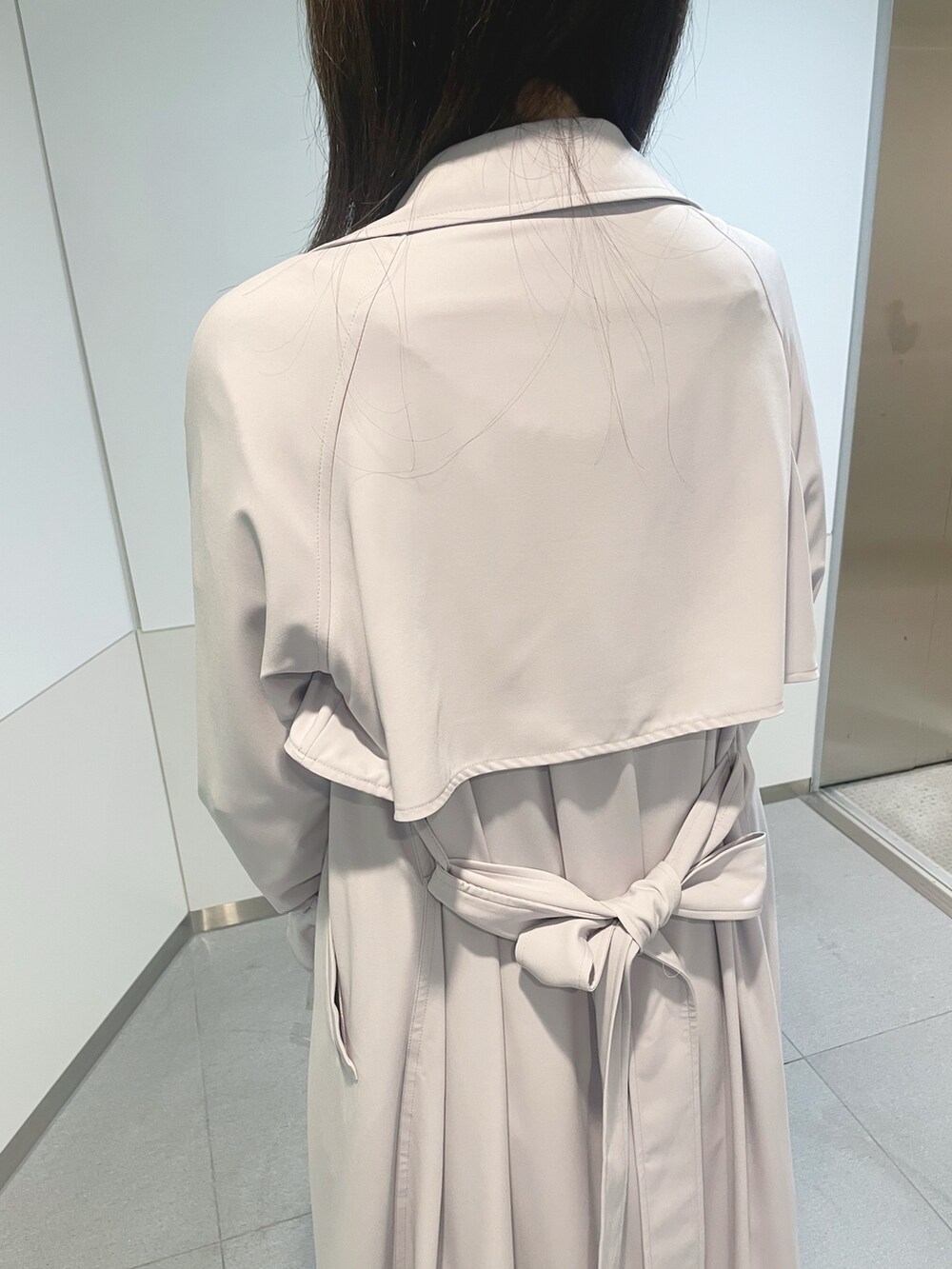 ブラック系のハンドバッグ、パープル系のトレンチコート、ホワイト系のニット/セーターを着用したレディースの冬コーディネートの7枚目の写真