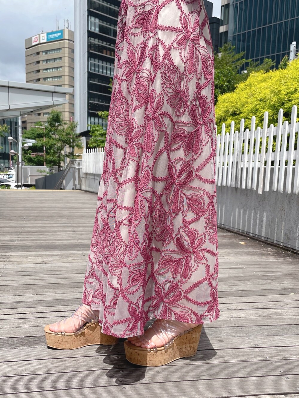 レッド系のスカート、グレー系のニット/セーター、ホワイト系のボストンバッグを着用したレディースの春コーディネートの6枚目の写真