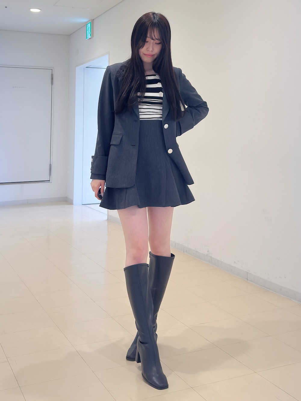 グレー系のテーラードジャケット、その他のニット/セーター、グレー系のスカートを着用したレディースの冬コーディネートの2枚目の写真