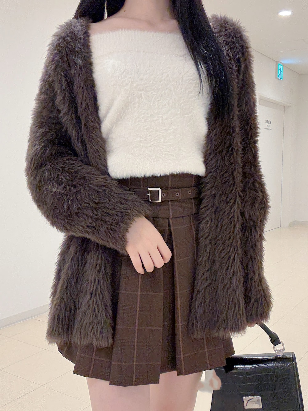 ブラウン系のカーディガン/ボレロ、ホワイト系のニット/セーター、ブラウン系のスカートを着用したレディースの秋コーディネートの5枚目の写真