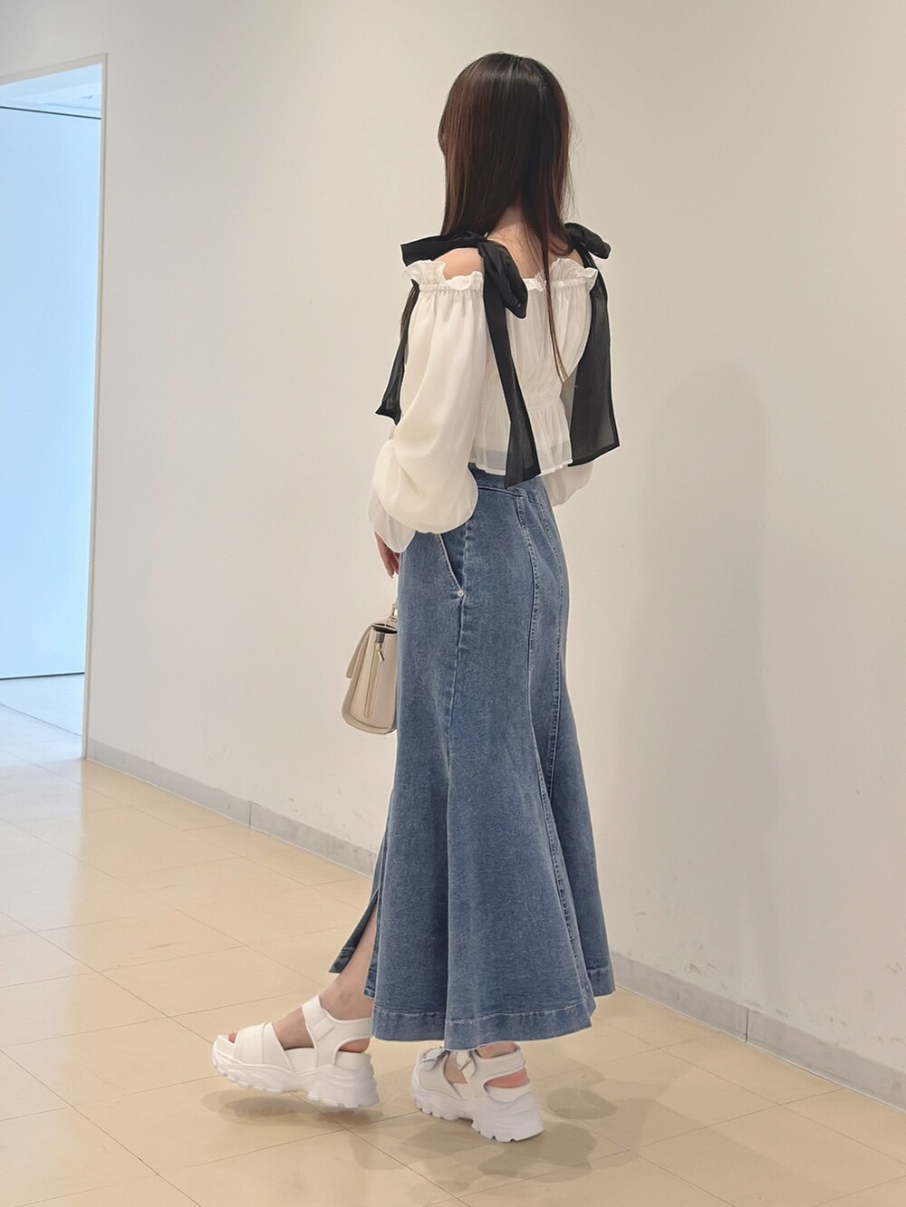 ホワイト系のシャツ/ブラウス、ブルー系のスカート、ホワイト系のハンドバッグを着用したレディースの春コーディネートの5枚目の写真