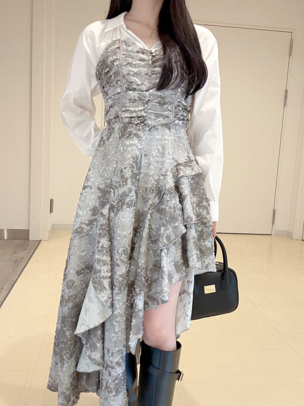 グリーン系のワンピース、ブラック系のハンドバッグ、ブラック系のブーツを着用したレディースの秋コーディネートの6枚目の写真