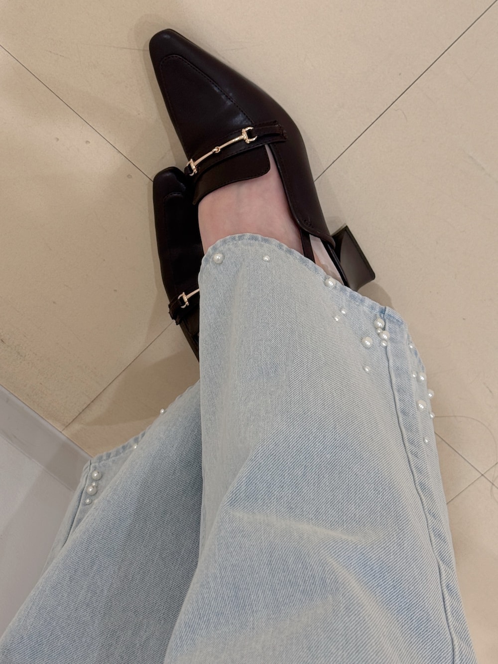 ホワイト系のシャツ/ブラウス、ブルー系のデニムパンツ、ブラウン系のハンドバッグを着用したレディースの春コーディネートの7枚目の写真