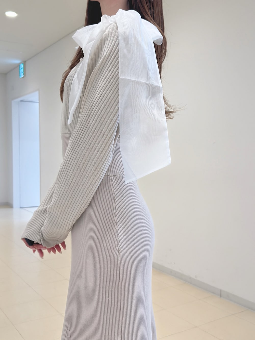 ホワイト系のワンピース、ブラウン系のブーツを着用したレディースの冬コーディネートの5枚目の写真