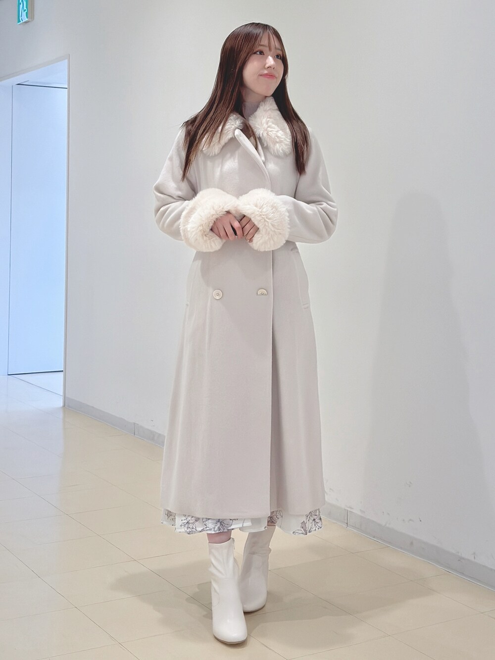 ホワイト系のその他アウター、ベージュ系のワンピース、ホワイト系のブーツを着用したレディースの冬コーディネートの4枚目の写真