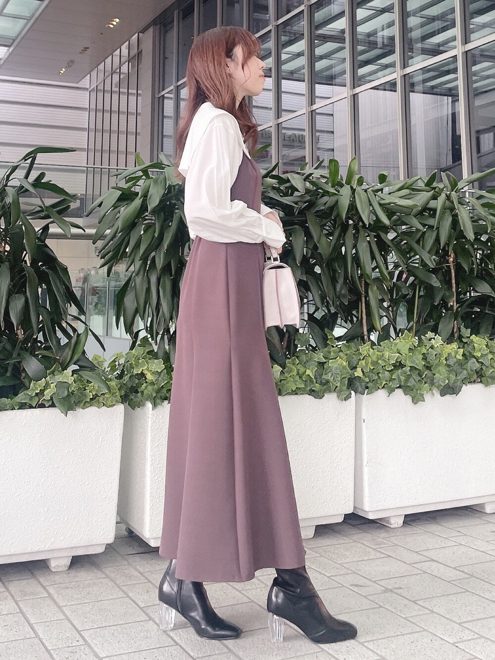 パープル系のワンピース、ブラック系のブーツを着用したレディースの冬コーディネートの4枚目の写真