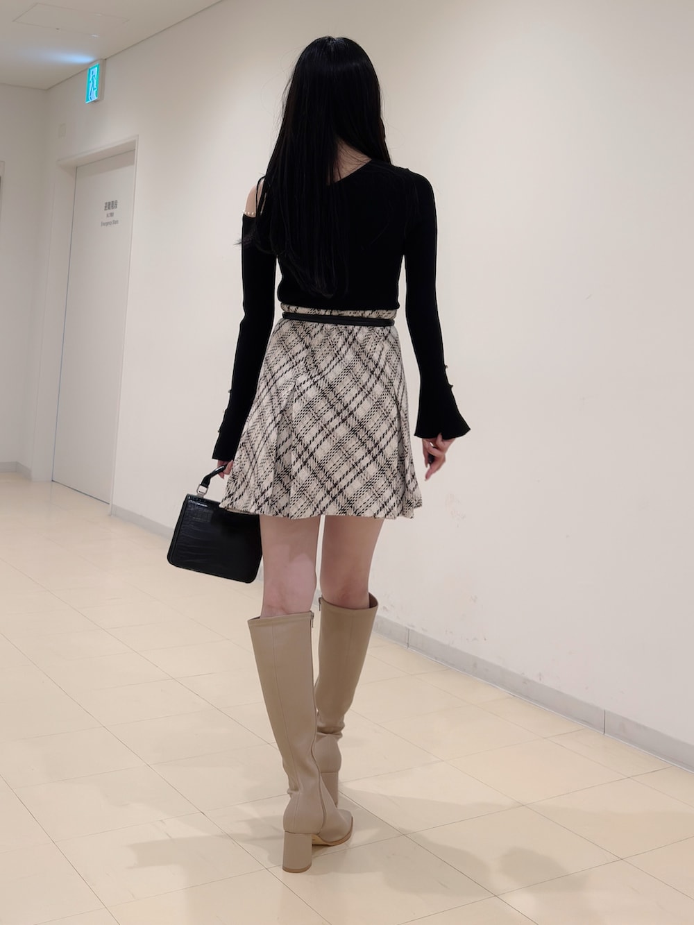 ブラック系のニット/セーター、ホワイト系のその他パンツ、ベージュ系のブーツを着用したレディースの秋コーディネートの5枚目の写真