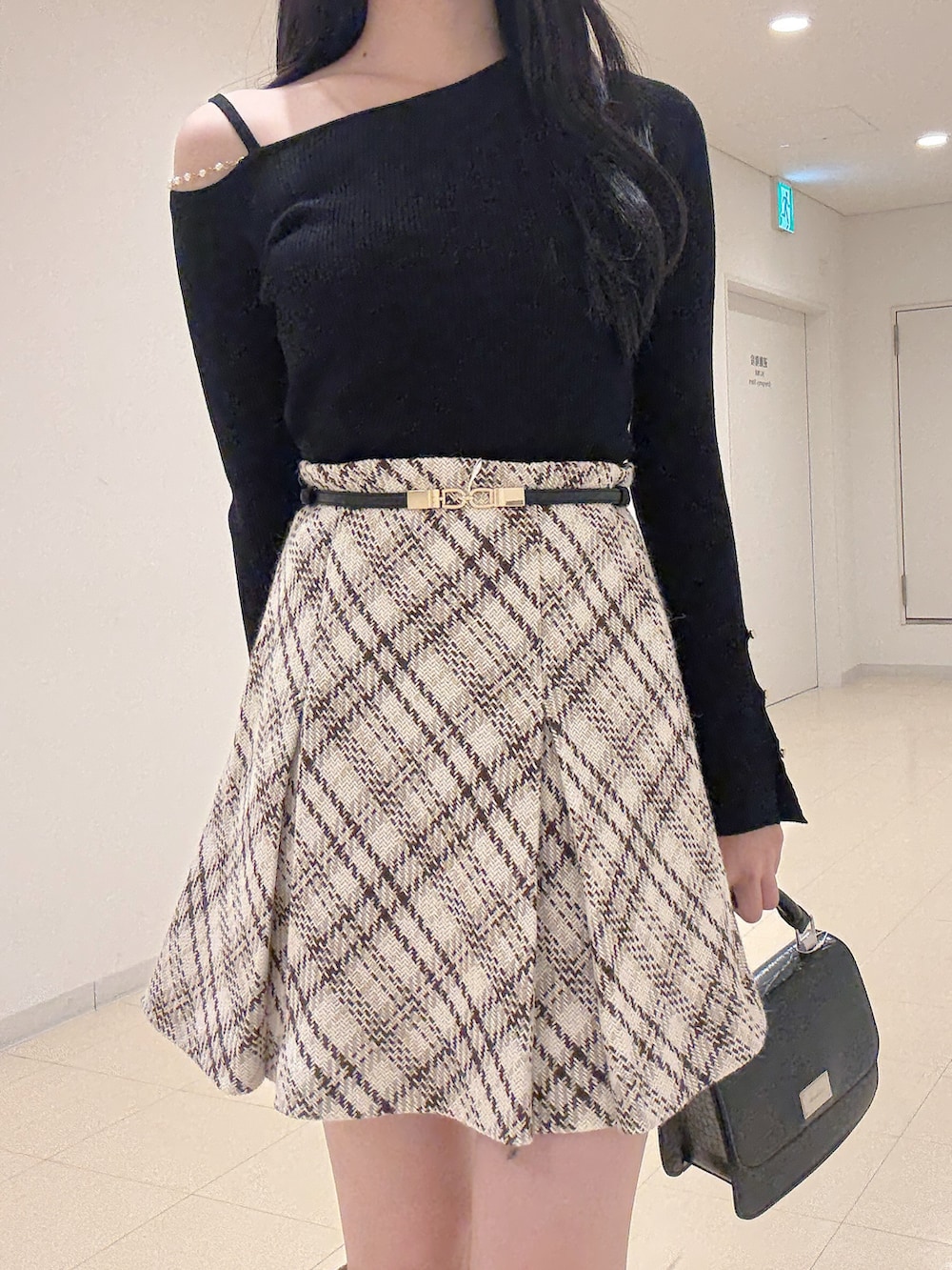 ブラック系のニット/セーター、ホワイト系のその他パンツ、ベージュ系のブーツを着用したレディースの秋コーディネートの6枚目の写真