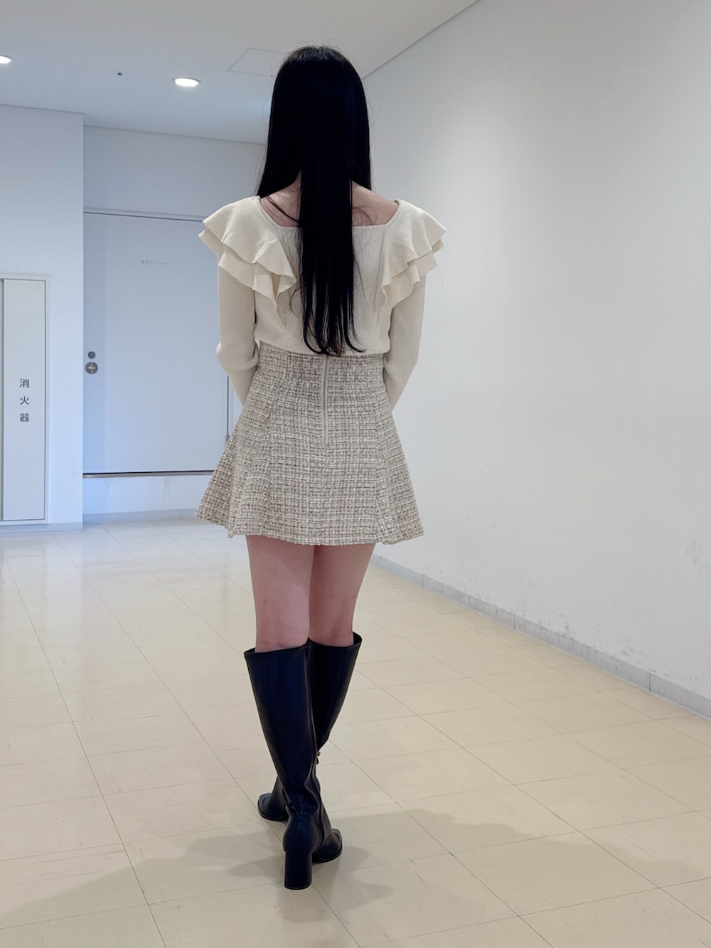 ホワイト系のニット/セーター、ベージュ系のスカート、ブラウン系のハンドバッグを着用したレディースの冬コーディネートの3枚目の写真