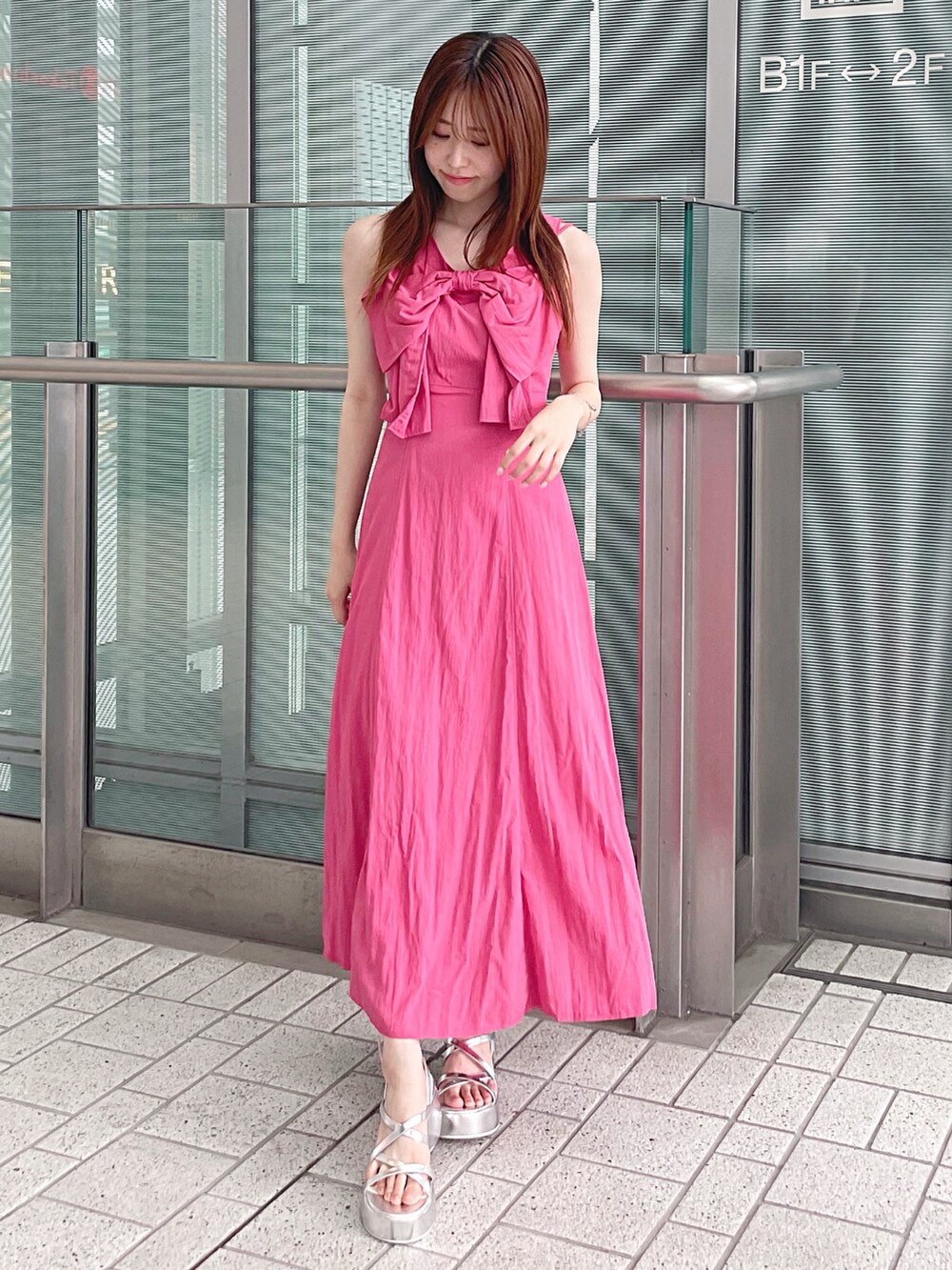 ピンク系のワンピース、シルバー系のサンダル、ホワイト系のチューブトップを着用したレディースの夏コーディネートの2枚目の写真