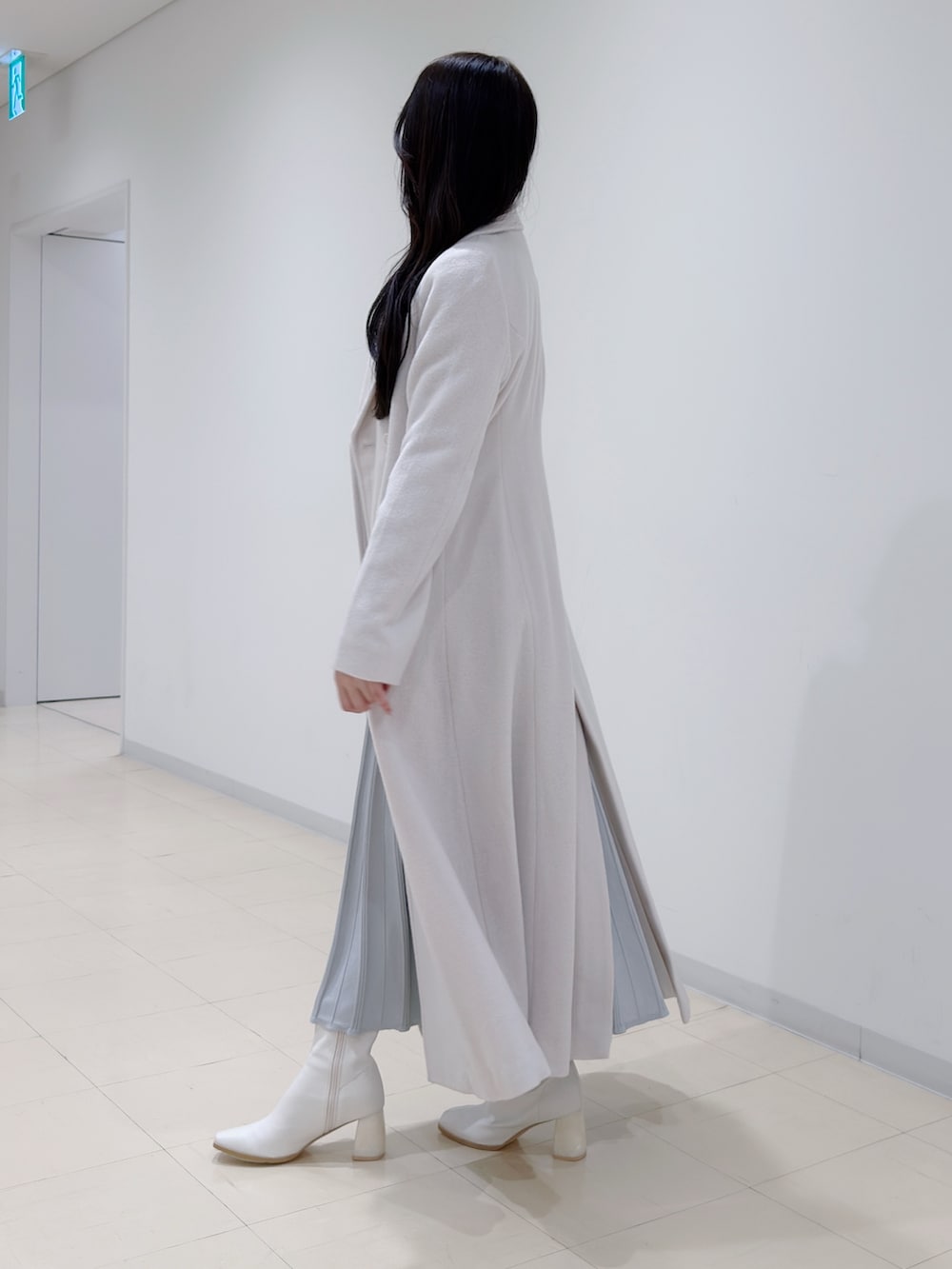 ホワイト系のその他アウター、グレー系のワンピース、ホワイト系のブーツを着用したレディースの冬コーディネートの3枚目の写真