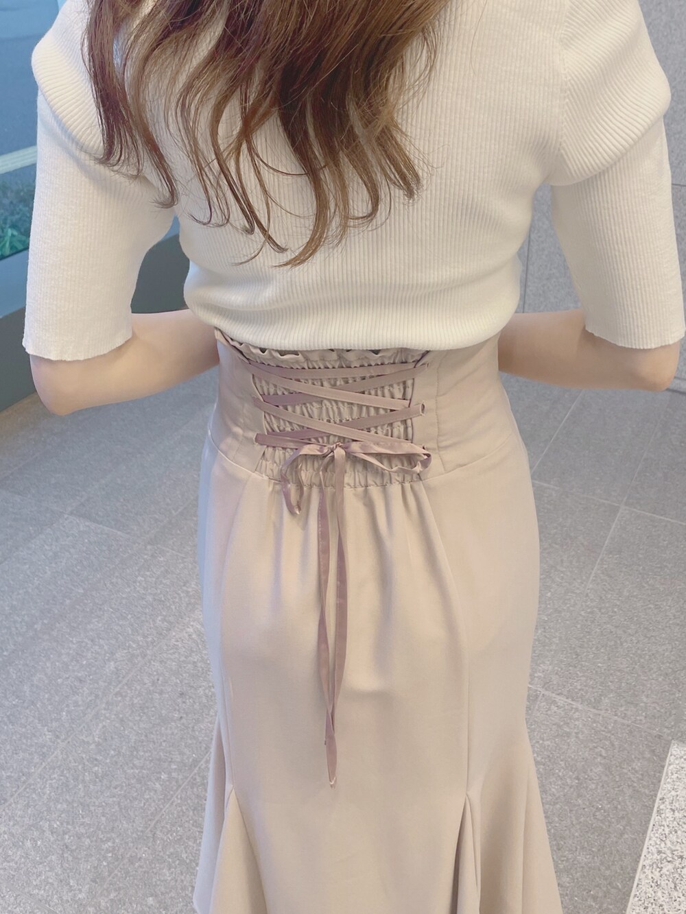 ピンク系のスカート、ホワイト系のサンダル、ホワイト系のニット/セーターを着用したレディースの春コーディネートの5枚目の写真