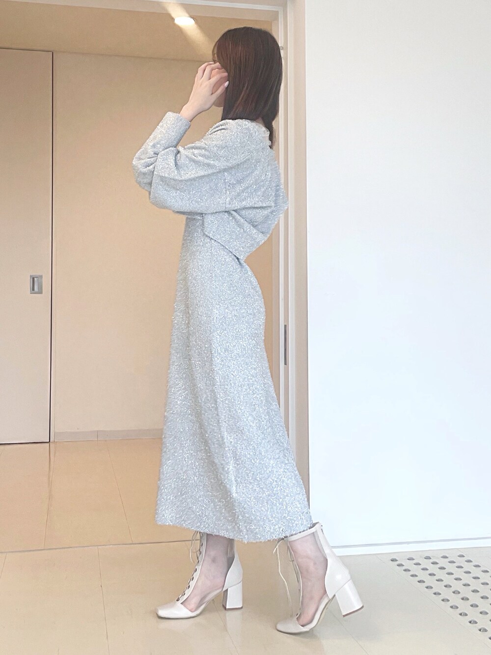 ホワイト系のブーツ、ブラック系のハンドバッグ、シルバー系のワンピースを着用したレディースの秋コーディネートの5枚目の写真