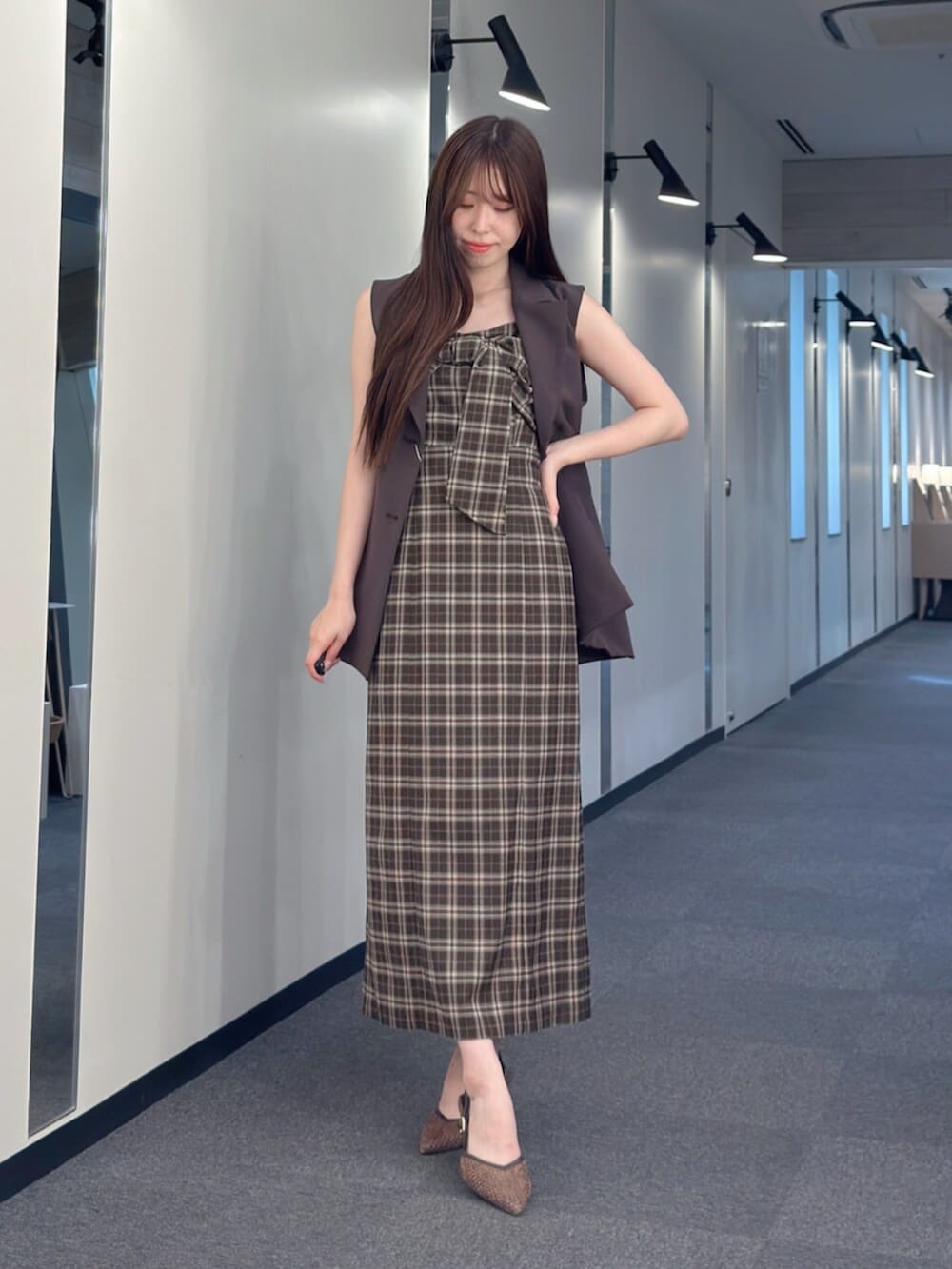 ブラウン系のパンプス、ブラウン系のベスト、その他のワンピースを着用したレディースの夏コーディネートの2枚目の写真