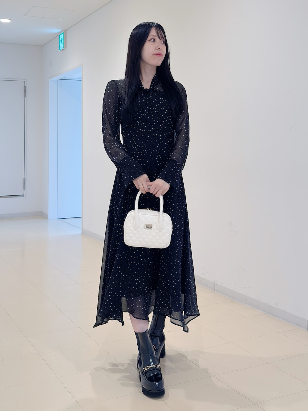 その他のワンピース、ホワイト系のハンドバッグ、ブラック系のブーツを着用したレディースの秋コーディネートの2枚目の写真