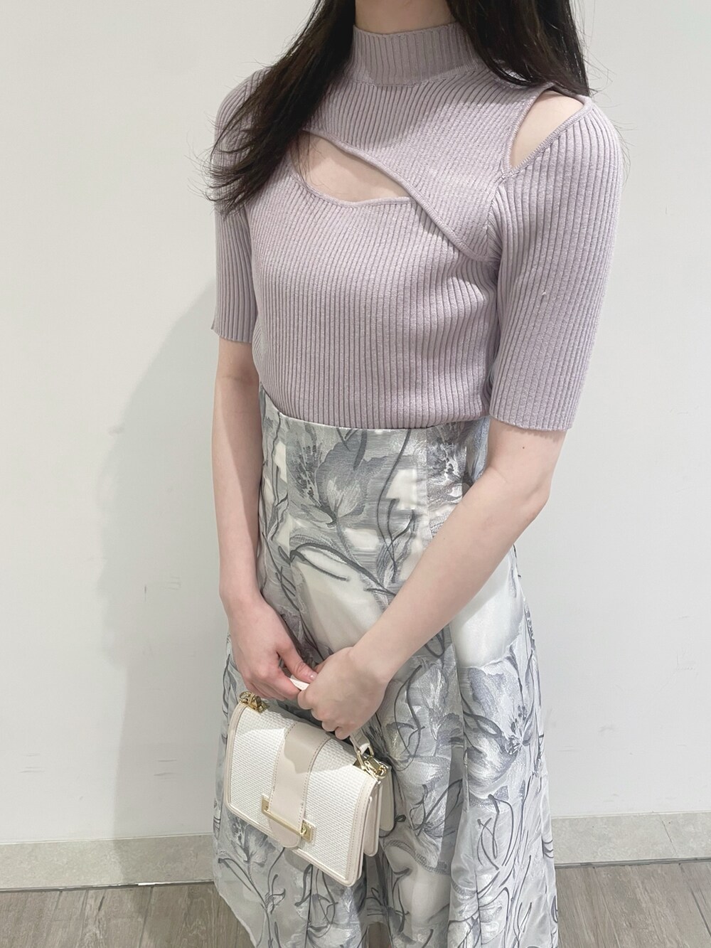 ホワイト系のパンプス、ピンク系のニット/セーター、グレー系のスカートを着用したレディースの春コーディネートの5枚目の写真