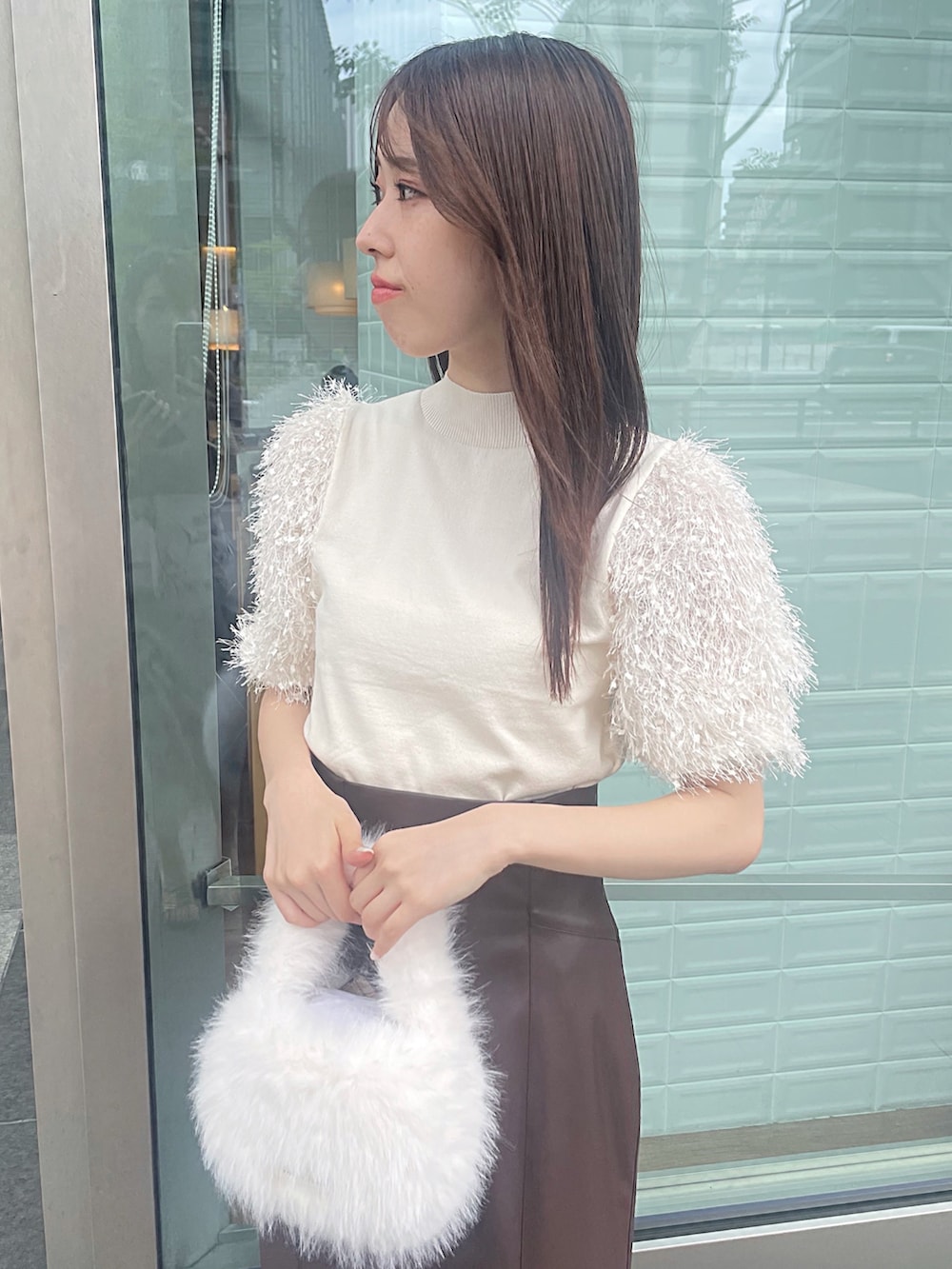 ホワイト系のニット/セーター、ブラウン系のスカート、ホワイト系のハンドバッグを着用したレディースの夏コーディネートの7枚目の写真