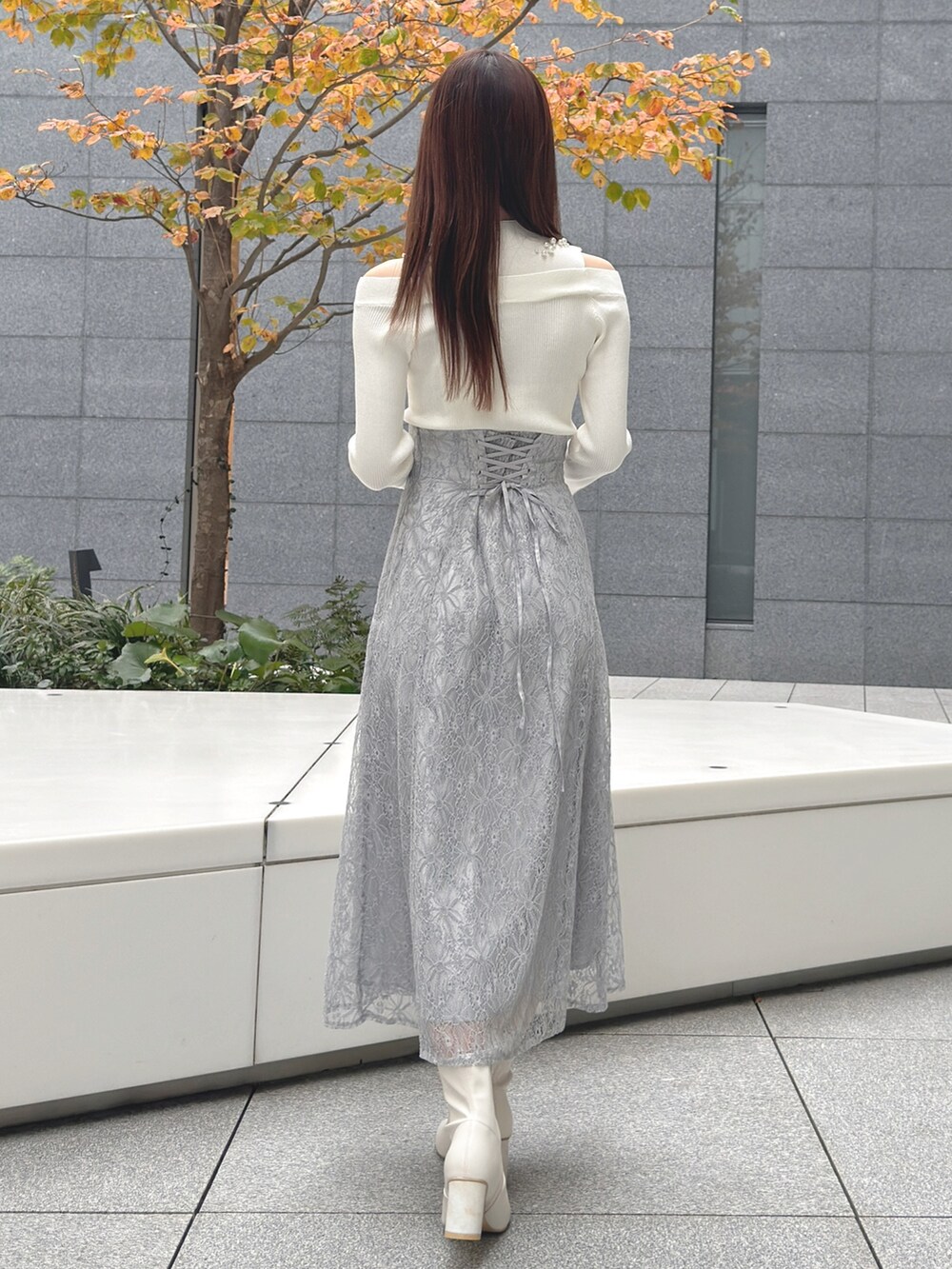 ホワイト系のハンドバッグ、ホワイト系のブーツ、ホワイト系のニット/セーターを着用したレディースの冬コーディネートの7枚目の写真