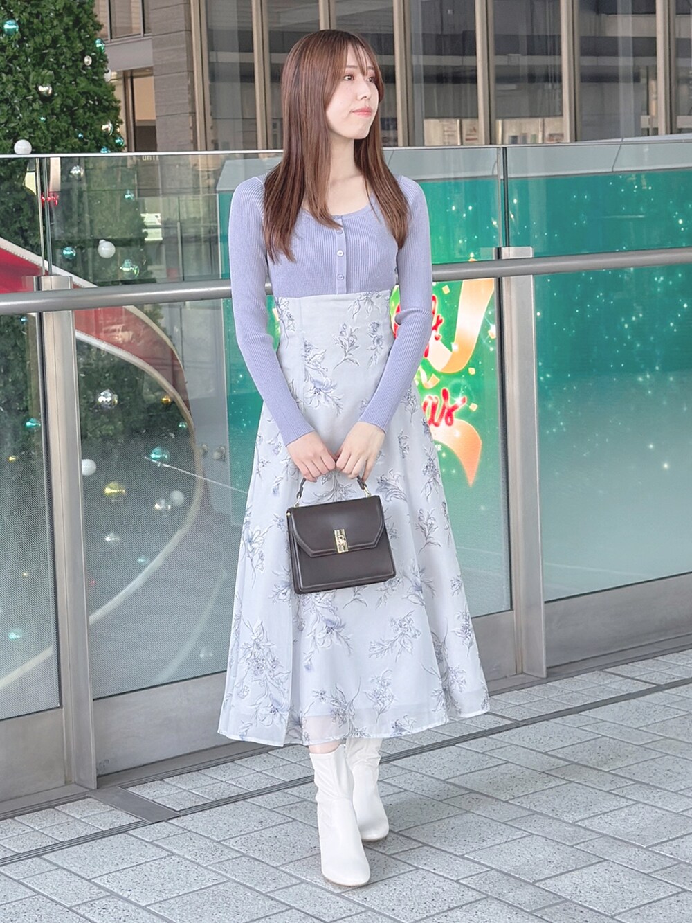 パープル系のワンピース、ホワイト系のブーツ、ブラウン系のハンドバッグを着用したレディースの秋コーディネートの3枚目の写真