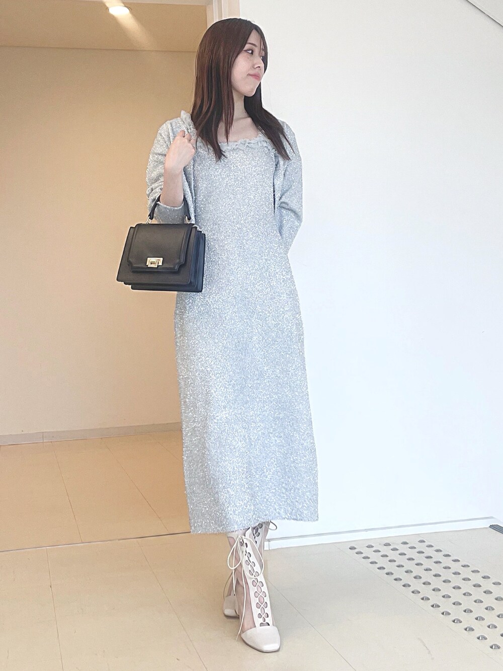ホワイト系のブーツ、ブラック系のハンドバッグ、シルバー系のワンピースを着用したレディースの秋コーディネートの2枚目の写真
