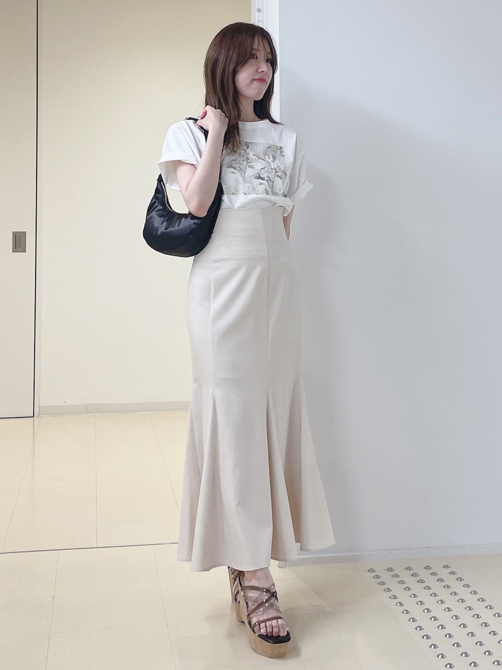 ホワイト系のTシャツ/カットソー、ホワイト系のスカート、ブラック系のショルダーバッグを着用したレディースの夏コーディネートの2枚目の写真