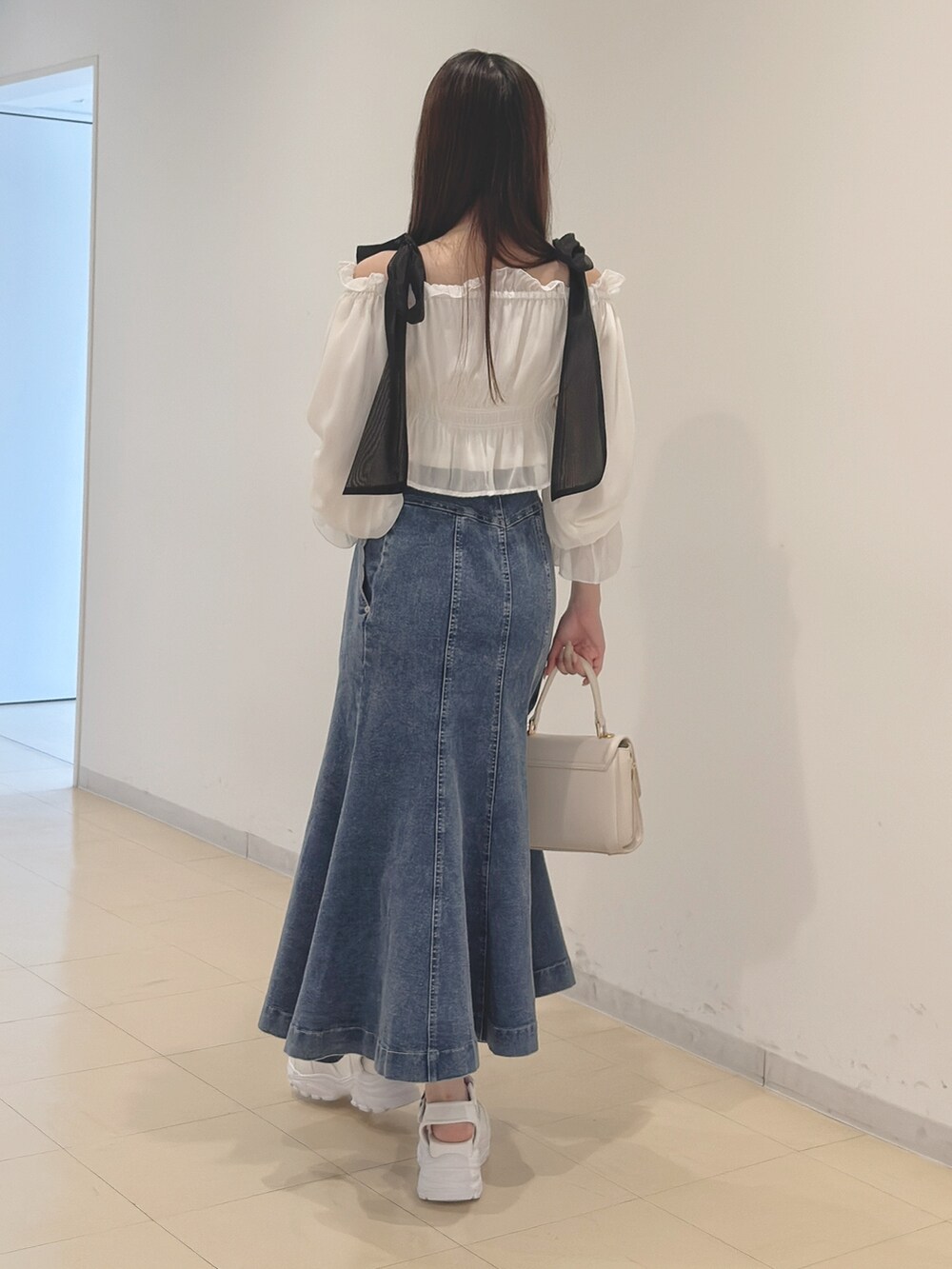 ホワイト系のシャツ/ブラウス、ブルー系のスカート、ホワイト系のハンドバッグを着用したレディースの春コーディネートの4枚目の写真