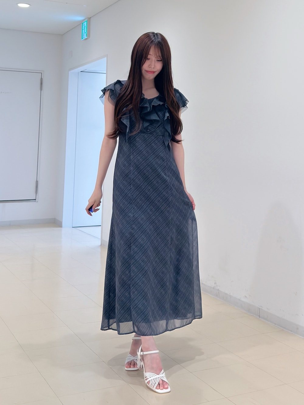 ブラック系のワンピース、ホワイト系のサンダルを着用したレディースの夏コーディネートの2枚目の写真