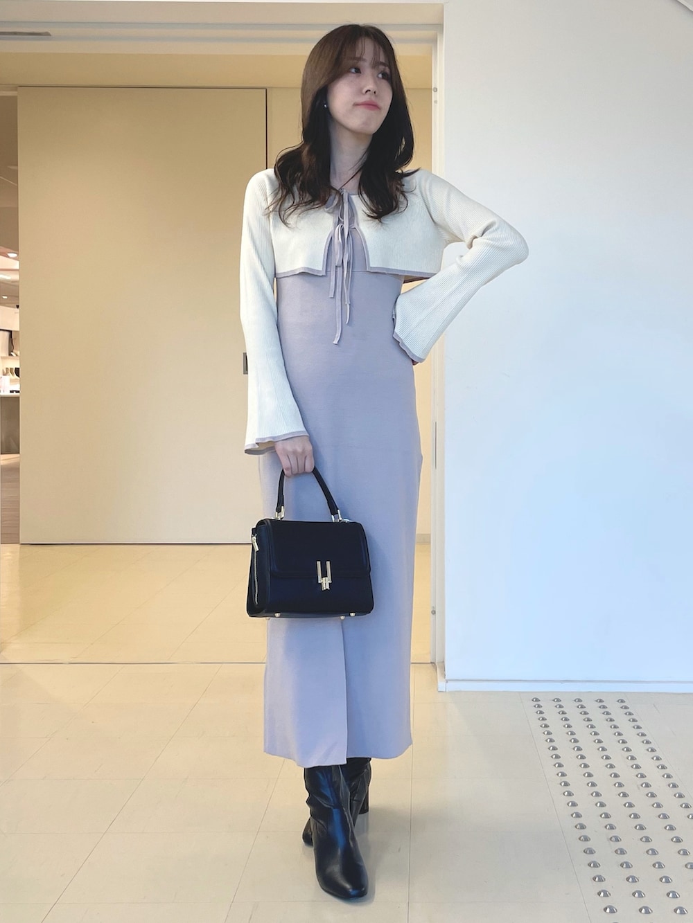 ホワイト系のその他アウター、ピンク系のワンピース、ブラック系のブーツを着用したレディースの秋コーディネートの5枚目の写真