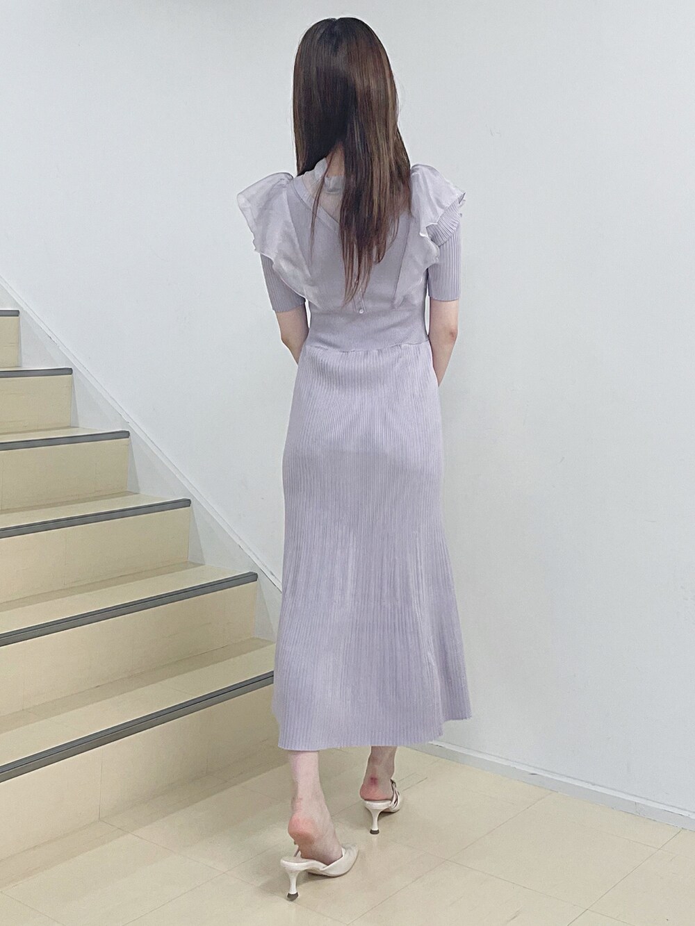パープル系のワンピース、シルバー系のショルダーバッグ、ベージュ系のパンプスを着用したレディースの夏コーディネートの5枚目の写真