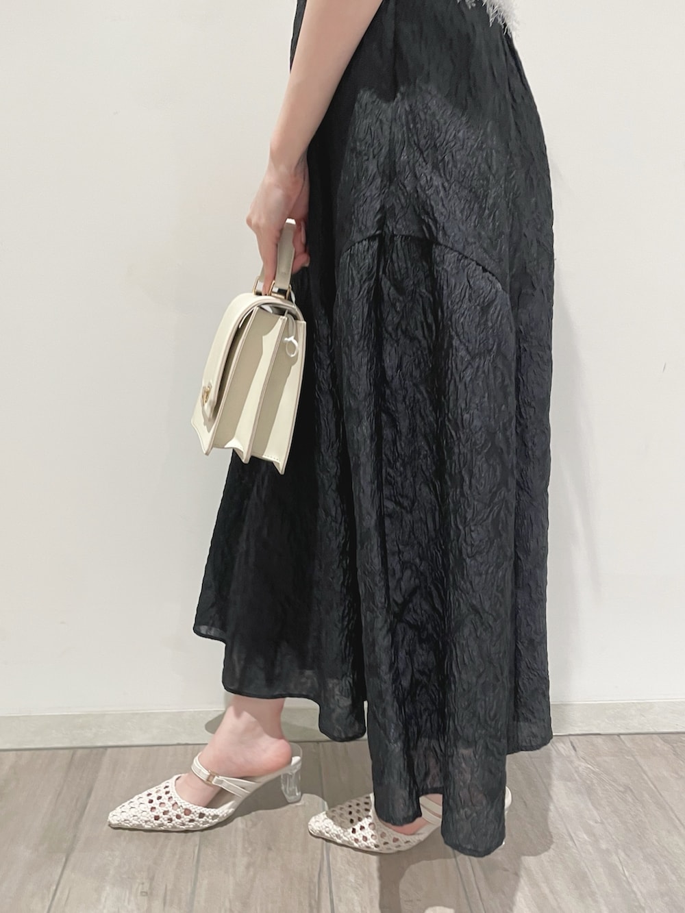 ブラック系のスカート、ホワイト系のパンプス、ホワイト系のカーディガン/ボレロを着用したレディースの冬コーディネートの6枚目の写真