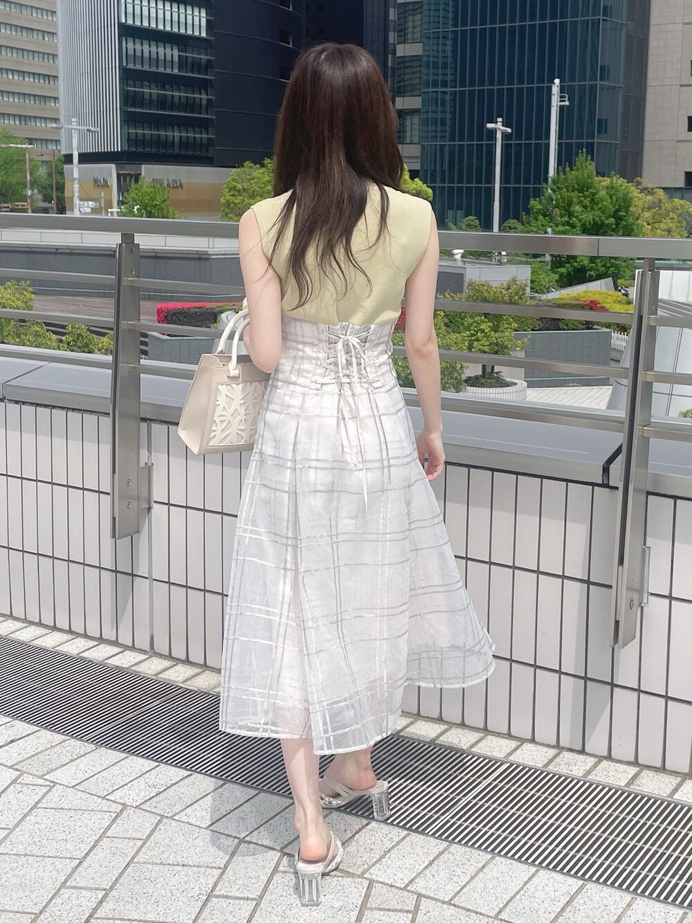 ベージュ系のショルダーバッグ、グリーン系のワンピース、その他のパンプスを着用したレディースの春コーディネートの4枚目の写真