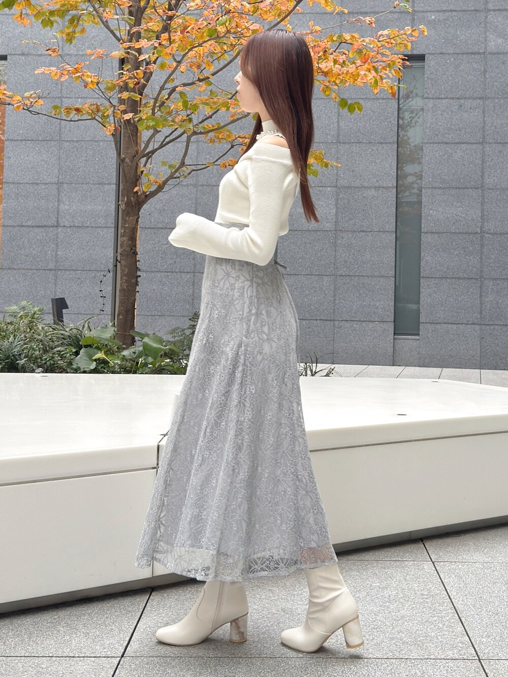 ホワイト系のハンドバッグ、ホワイト系のブーツ、ホワイト系のニット/セーターを着用したレディースの冬コーディネートの6枚目の写真