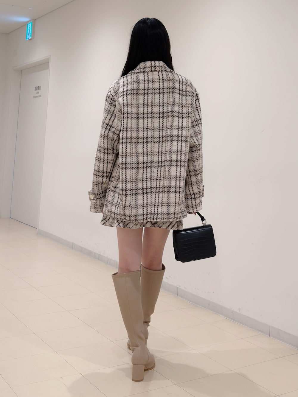 ブラック系のニット/セーター、ホワイト系のその他アウター、ホワイト系のその他パンツを着用したレディースの秋コーディネートの5枚目の写真