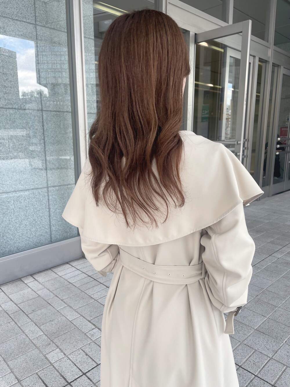 ピンク系のワンピース、ベージュ系のトレンチコート、ブラック系のショルダーバッグを着用したレディースの秋コーディネートの7枚目の写真