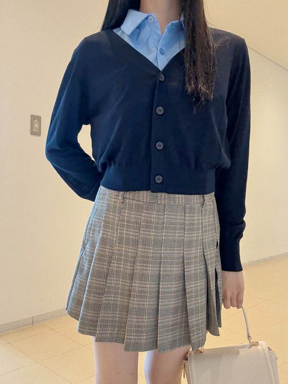 ブルー系のシャツ/ブラウス、グレー系のスカート、ホワイト系のハンドバッグを着用したレディースの夏コーディネートの6枚目の写真