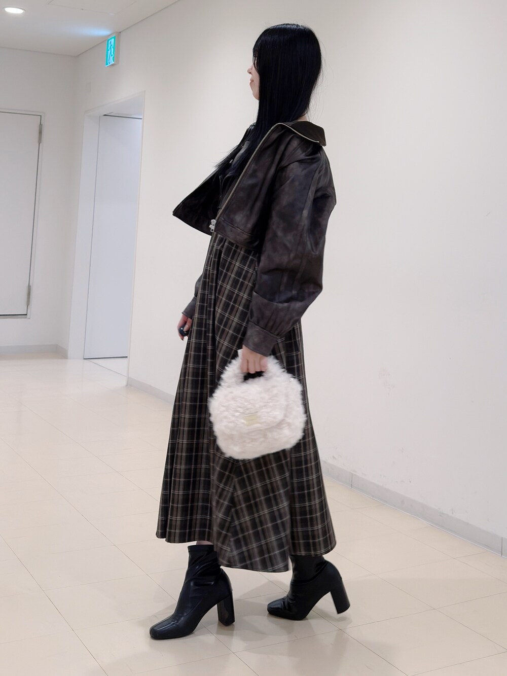 ブラウン系のブルゾン、ホワイト系のハンドバッグ、ブラウン系のワンピースを着用したレディースの秋コーディネートの4枚目の写真