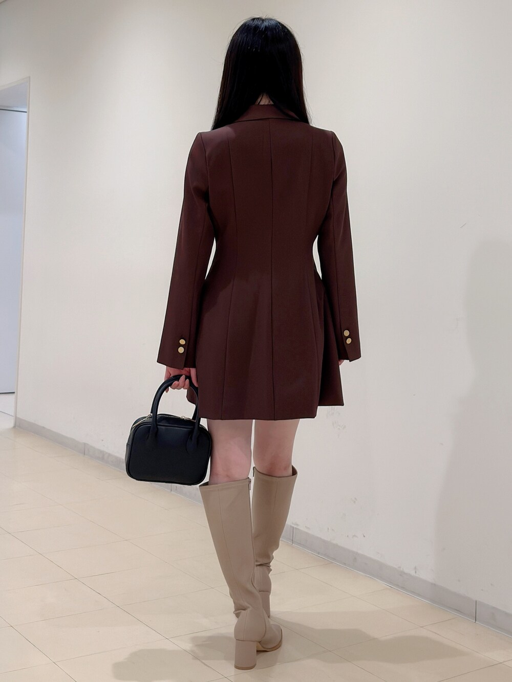 ベージュ系のブーツ、ブラウン系のワンピース、ブラック系のハンドバッグを着用したレディースの夏コーディネートの6枚目の写真