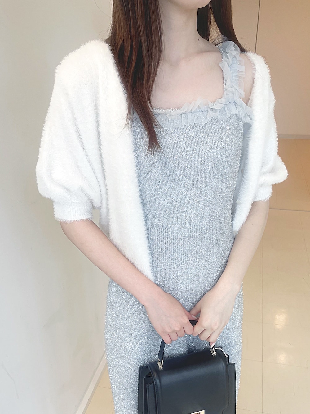 ホワイト系のカーディガン/ボレロ、シルバー系のワンピース、ブラック系のハンドバッグを着用したレディースの秋コーディネートの6枚目の写真