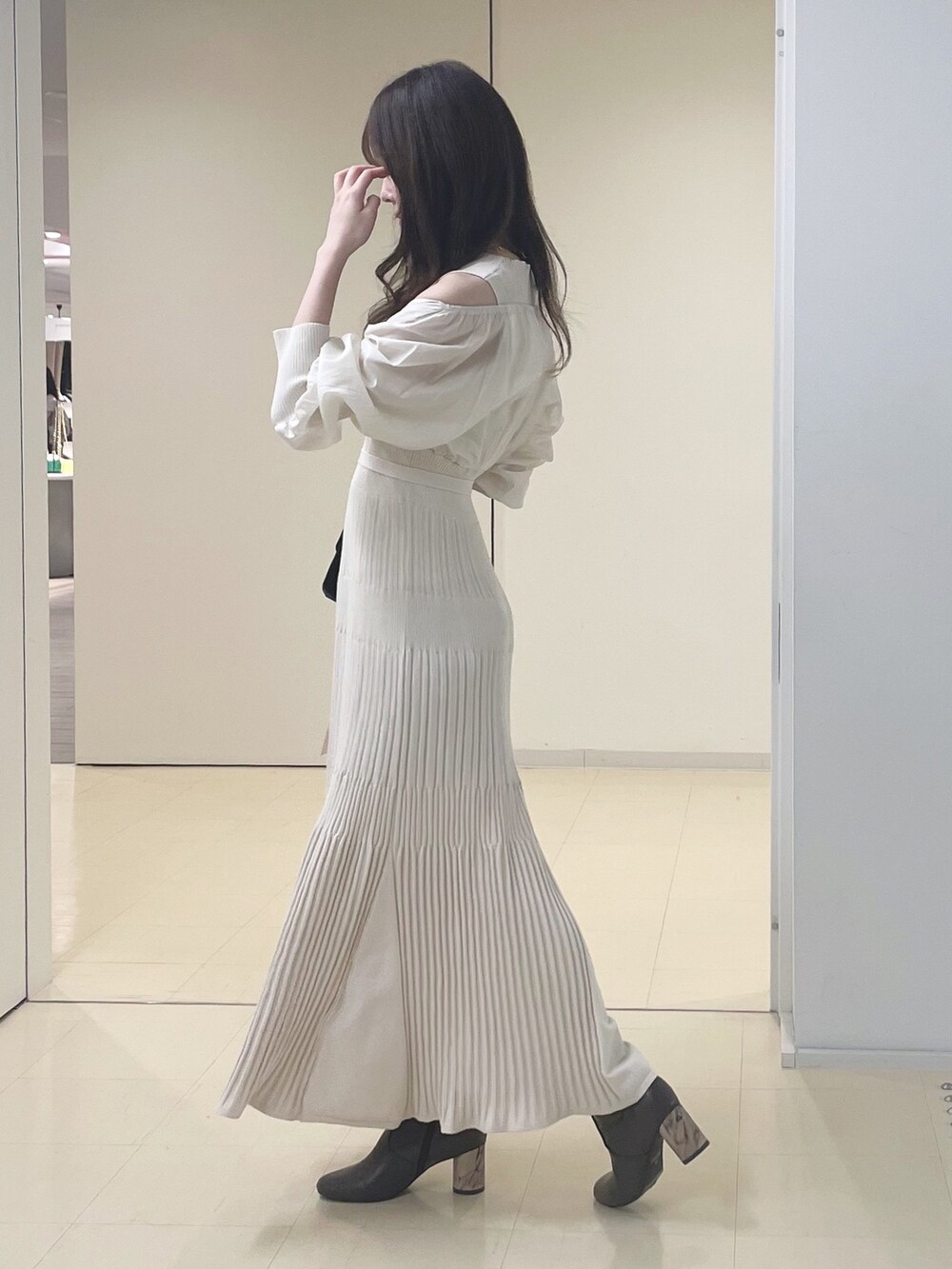 ベージュ系のカーディガン/ボレロ、ブラウン系のブーツ、ホワイト系のワンピースを着用したレディースの冬コーディネートの6枚目の写真