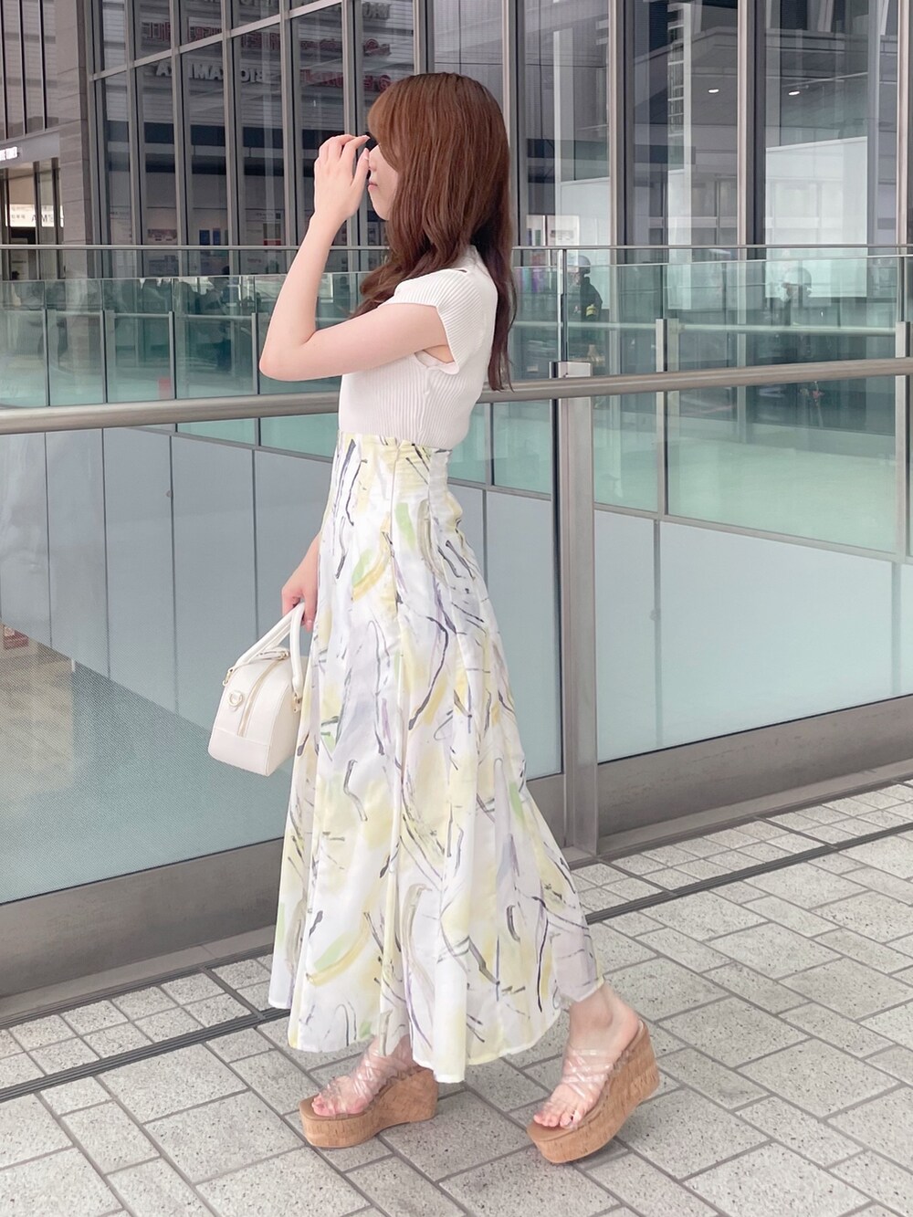 ホワイト系のニット/セーター、イエロー系のスカート、ホワイト系のボストンバッグを着用したレディースの夏コーディネートの5枚目の写真