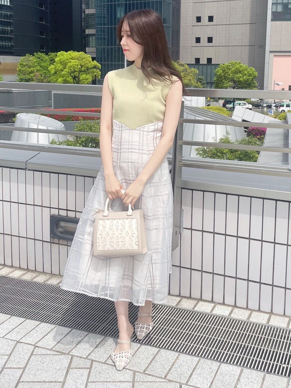 ベージュ系のショルダーバッグ、グリーン系のワンピース、その他のパンプスを着用したレディースの春コーディネートの2枚目の写真