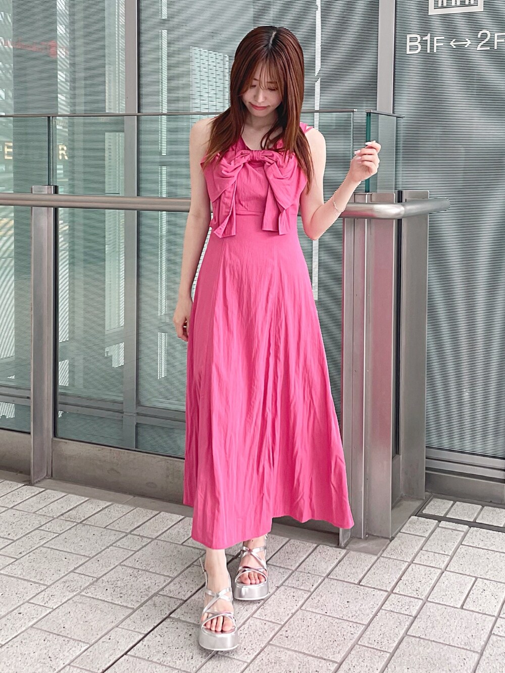 ピンク系のワンピース、シルバー系のサンダル、ホワイト系のチューブトップを着用したレディースの夏コーディネートの3枚目の写真