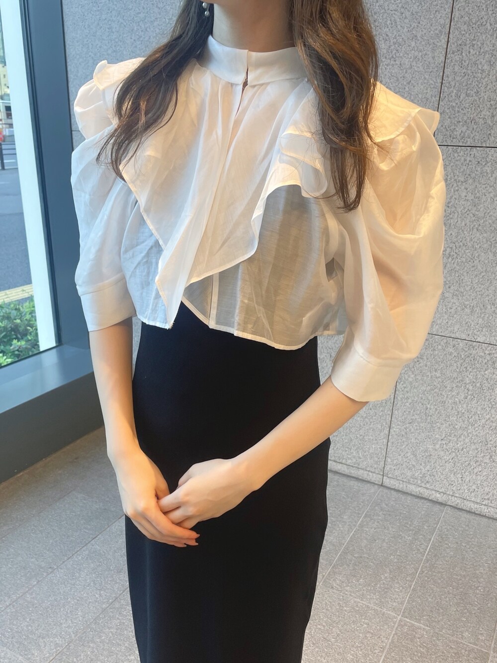 ブラック系のワンピース、シルバー系のハンドバッグ、ブラック系のブーツを着用したレディースの夏コーディネートの5枚目の写真