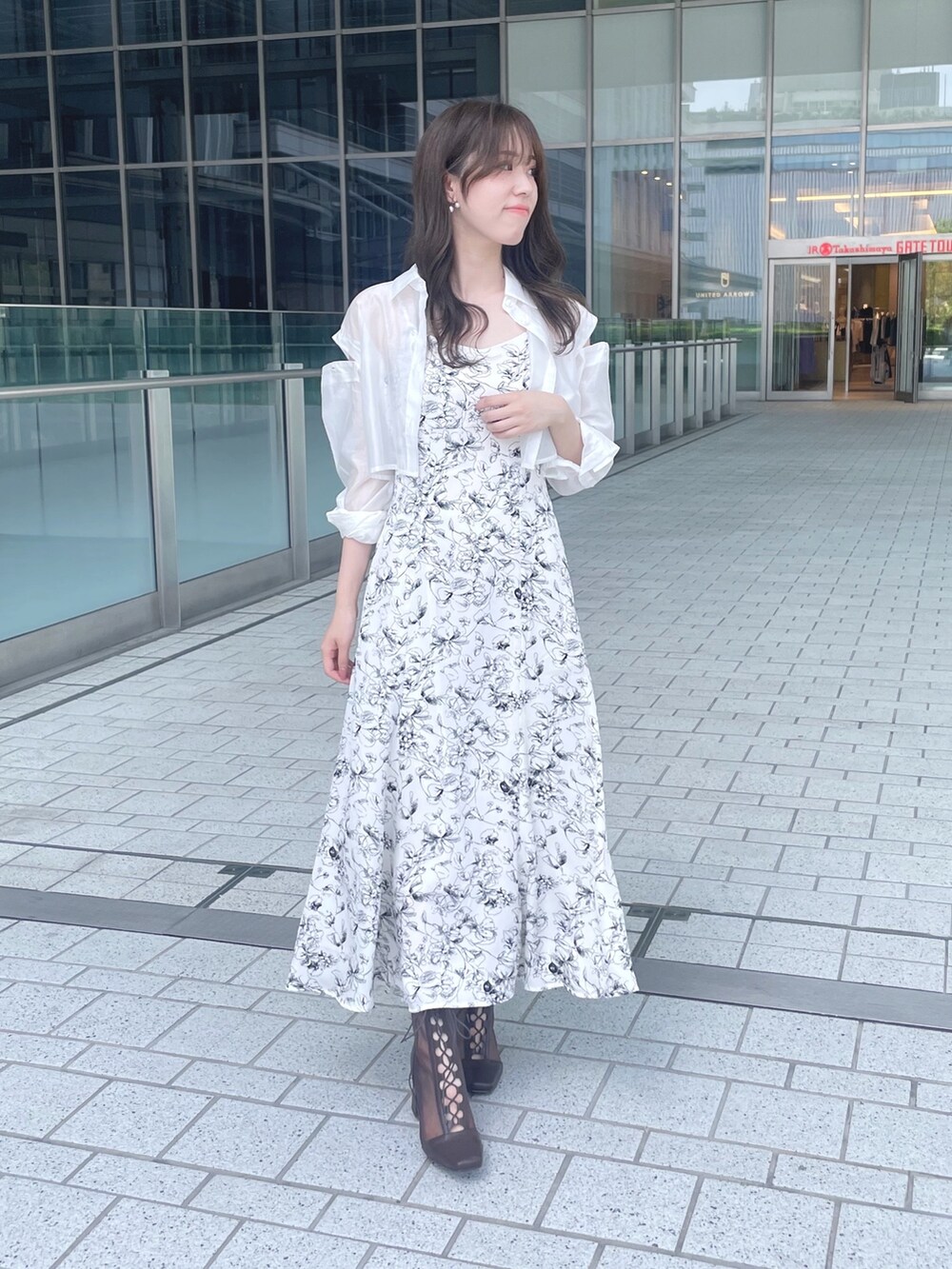 ホワイト系のワンピース、ブラウン系のブーツを着用したレディースの夏コーディネートの4枚目の写真