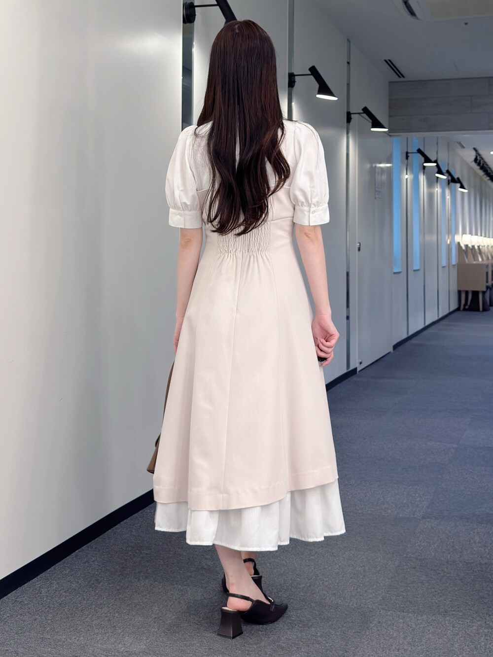 ベージュ系のワンピース、ブラウン系のハンドバッグ、ブラウン系のパンプスを着用したレディースの春コーディネートの4枚目の写真