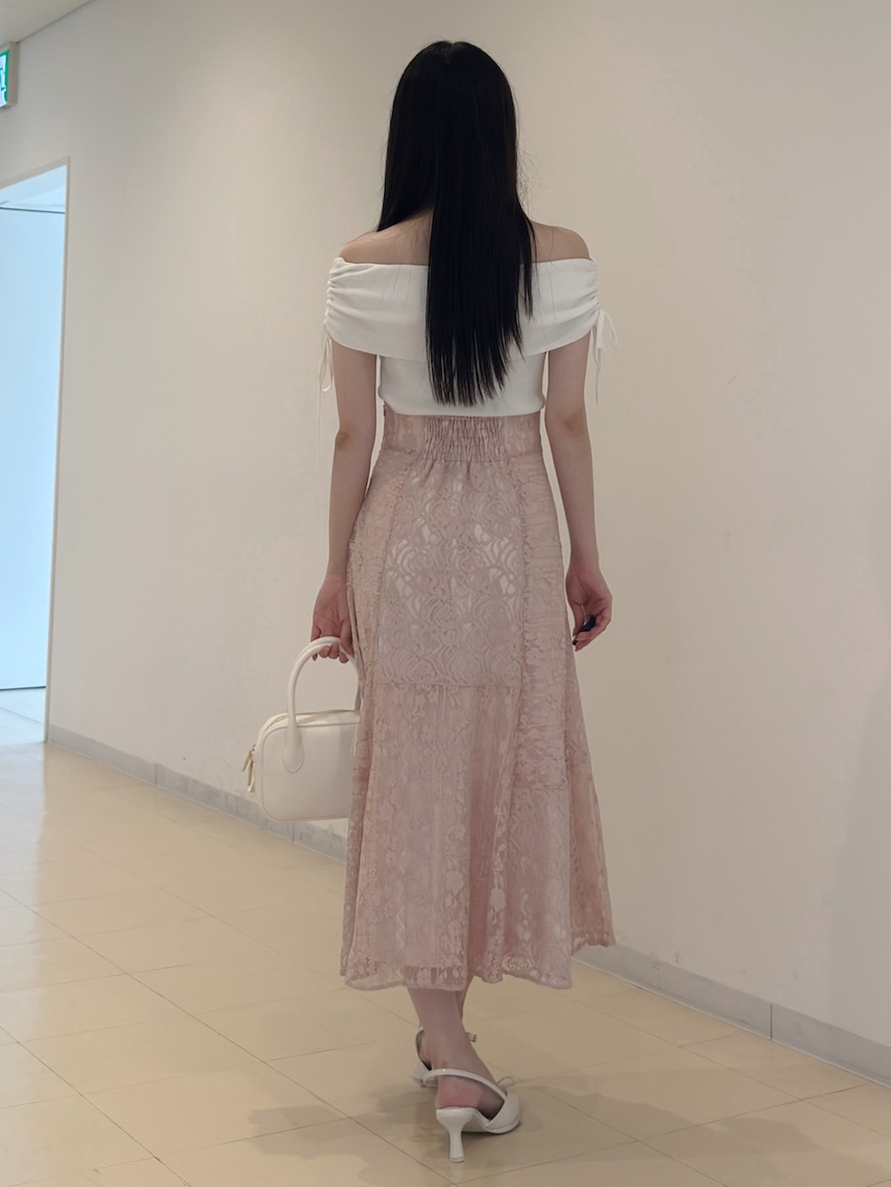 ホワイト系のニット/セーター、ブラック系のチューブトップ、ピンク系のスカートを着用したレディースの夏コーディネートの3枚目の写真