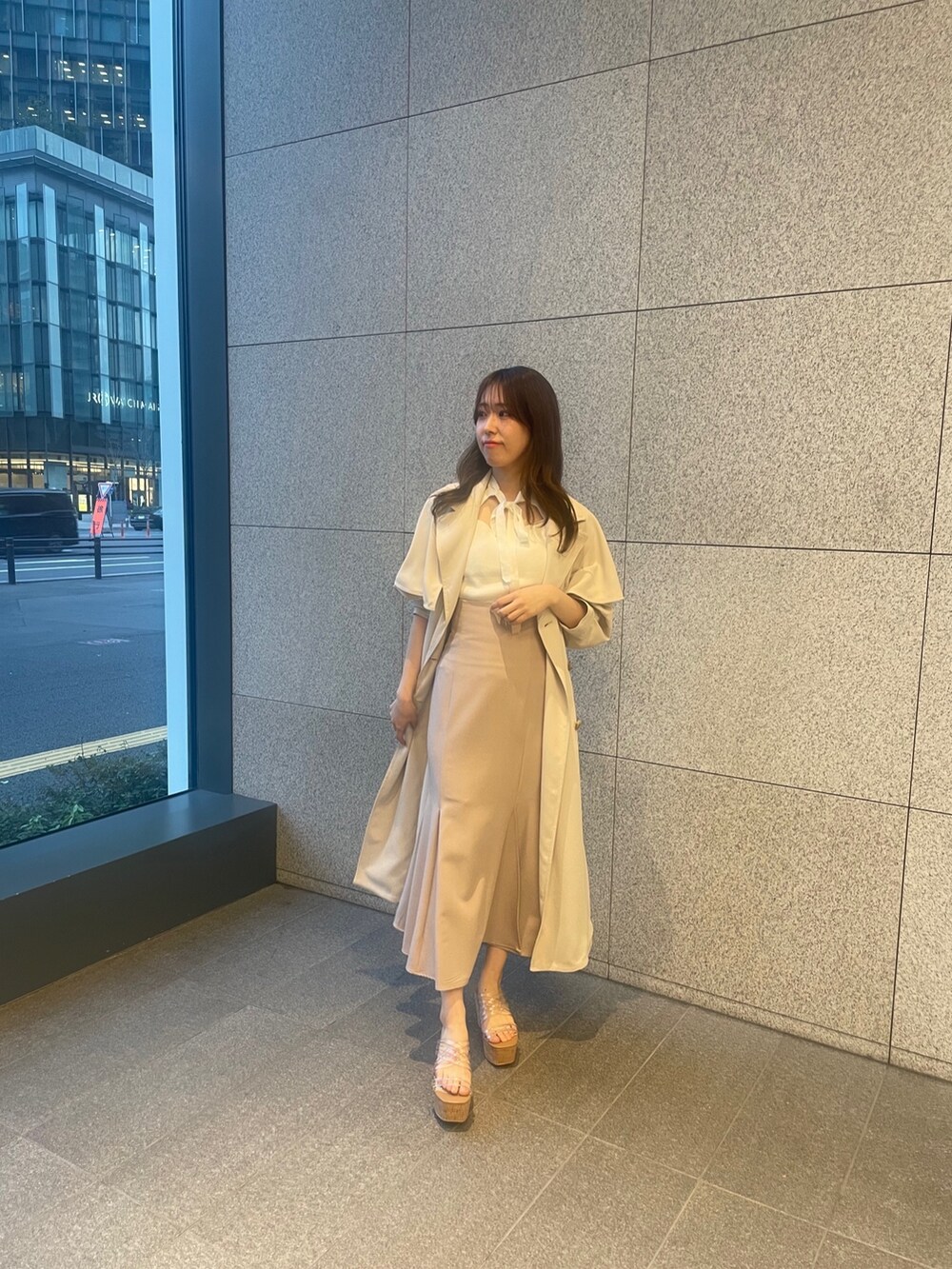 ピンク系のスカート、ホワイト系のニット/セーター、ホワイト系のトレンチコートを着用したレディースの春コーディネートの3枚目の写真