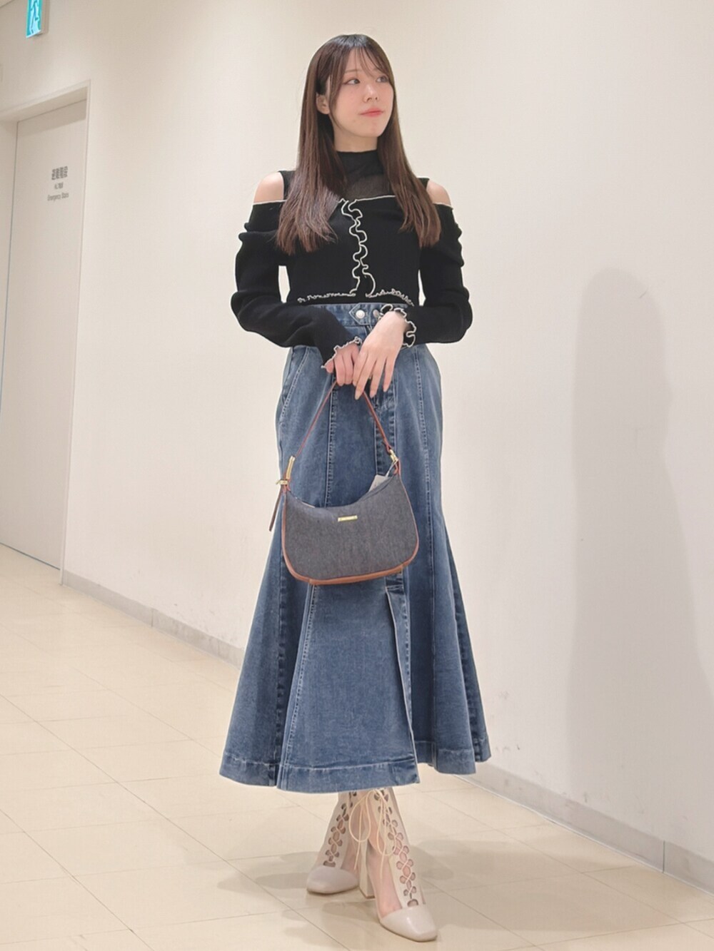 ホワイト系のブーツ、ブルー系のショルダーバッグ、ブラック系のニット/セーターを着用したレディースの春コーディネートの3枚目の写真